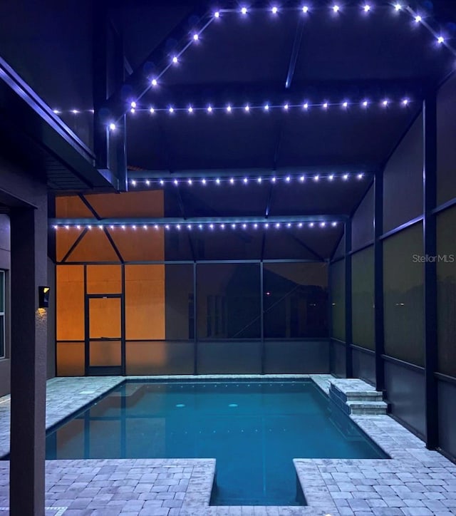 1833 Benoit Ter, Davenport, FL 33837 - pool at night with an outdoor pool, glass enclosure, and a patio area