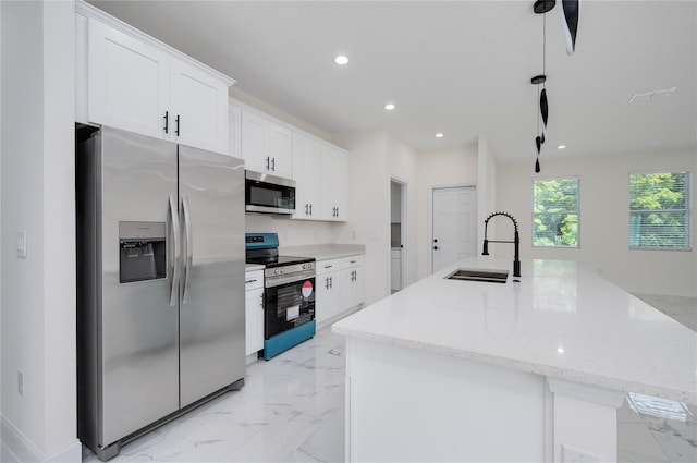 1157 W Hancock Dr, Deltona, FL 32725 - kitchen with stainless steel appliances, light marble finish flooring, recessed lighting, white cabinets, and an island with sink
