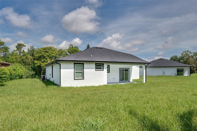 1157 W Hancock Dr, Deltona, FL 32725 - rear view of house featuring a yard, stucco siding, and roof with shingles