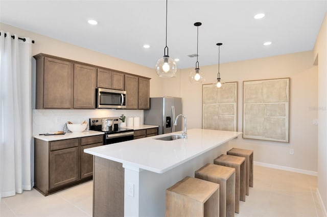 2302 Southbury Dr, Kissimmee, FL 34744 - kitchen with appliances with stainless steel finishes, a center island with sink, a breakfast bar, recessed lighting, and light countertops