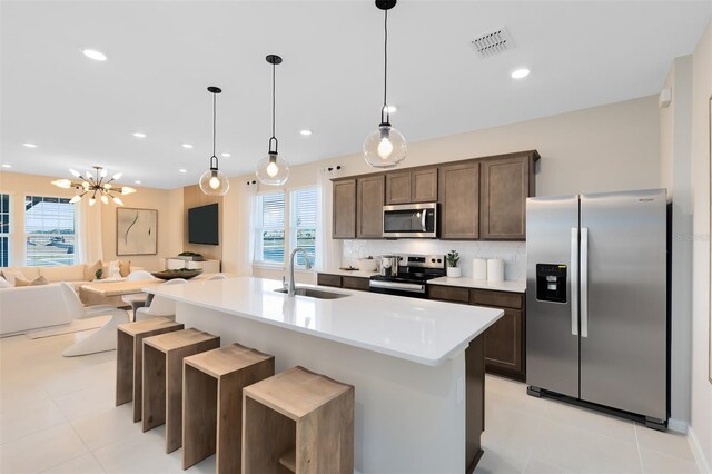 2302 Southbury Dr, Kissimmee, FL 34744 - kitchen with stainless steel appliances, dark brown cabinetry, open floor plan, healthy amount of natural light, and recessed lighting