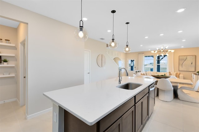 2302 Southbury Dr, Kissimmee, FL 34744 - kitchen with open floor plan, light tile patterned floors, light countertops, a kitchen island with sink, and hanging light fixtures