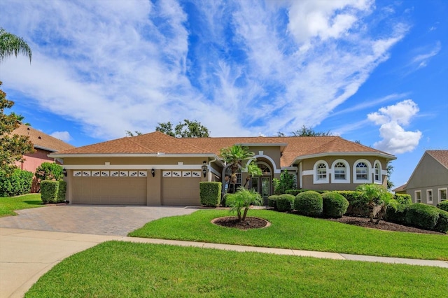 4216 Fawn Meadows Cir, Clermont, FL 34711 - mediterranean / spanish-style home featuring stucco siding, driveway, an attached garage, and a front yard