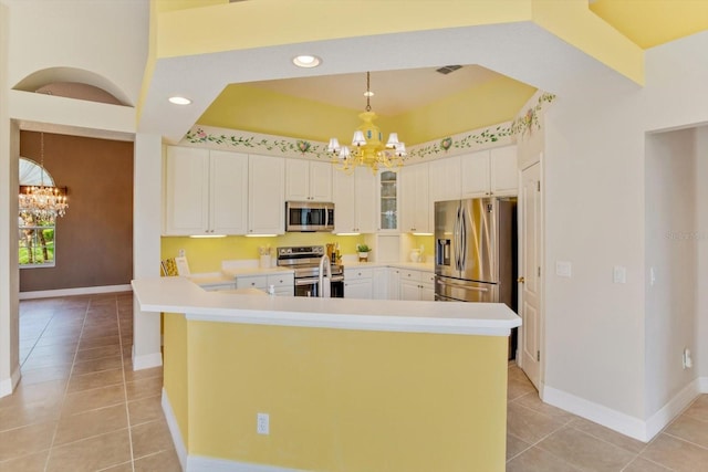 4216 Fawn Meadows Cir, Clermont, FL 34711 - kitchen with a chandelier, stainless steel appliances, light tile patterned floors, a tray ceiling, and recessed lighting