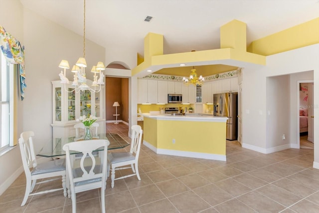 4216 Fawn Meadows Cir, Clermont, FL 34711 - kitchen with a chandelier, stainless steel appliances, high vaulted ceiling, light tile patterned flooring, and hanging light fixtures