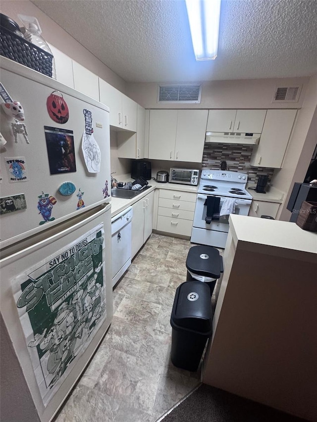 320 Forestway Cir Unit 203, Altamonte Springs, FL 32701 - kitchen with white appliances, under cabinet range hood, light countertops, a textured ceiling, and white cabinetry
