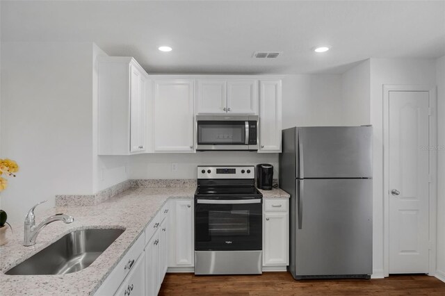 69 Pin Oak Dr, Palm Coast, FL 32164 - kitchen with stainless steel appliances, white cabinetry, light stone countertops, dark wood-style floors, and recessed lighting