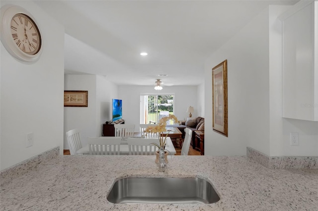 69 Pin Oak Dr, Palm Coast, FL 32164 - kitchen featuring light stone countertops, recessed lighting, white cabinetry, and open floor plan