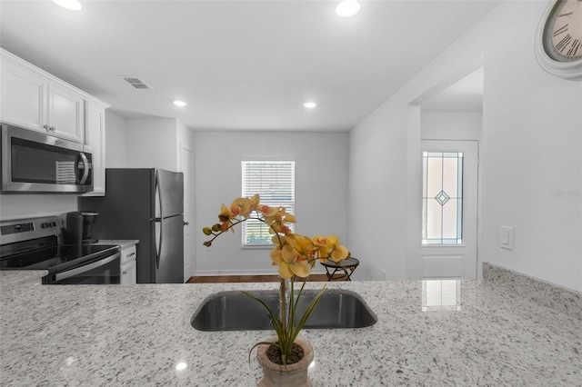 69 Pin Oak Dr, Palm Coast, FL 32164 - kitchen featuring stainless steel appliances, white cabinetry, light stone counters, and recessed lighting