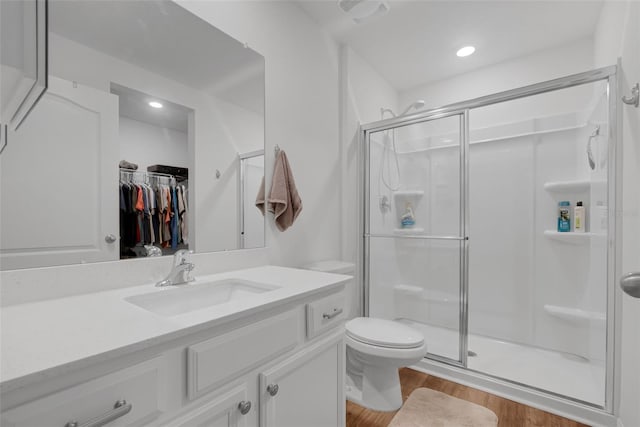 69 Pin Oak Dr, Palm Coast, FL 32164 - full bathroom featuring a stall shower, vanity, wood finished floors, a spacious closet, and recessed lighting