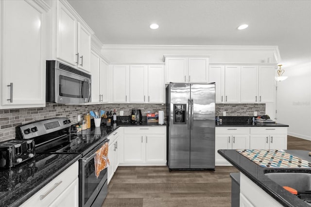 1608 Mohegan Blvd, Kissimmee, FL 34744 - kitchen with appliances with stainless steel finishes, white cabinets, dark wood-style flooring, decorative backsplash, and dark stone countertops