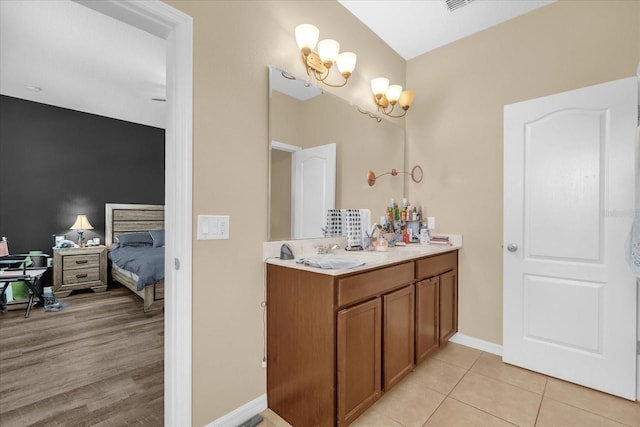 1608 Mohegan Blvd, Kissimmee, FL 34744 - bathroom featuring double vanity, ensuite bath, tile patterned flooring, and a chandelier