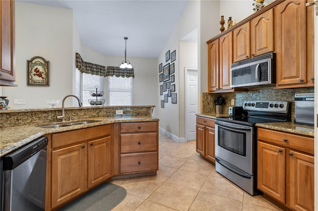 859 Leather Fern Ln, Mims, FL 32754 - kitchen with appliances with stainless steel finishes, stone countertops, backsplash, brown cabinetry, and lofted ceiling