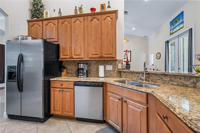 859 Leather Fern Ln, Mims, FL 32754 - kitchen featuring appliances with stainless steel finishes, light stone countertops, brown cabinetry, and recessed lighting