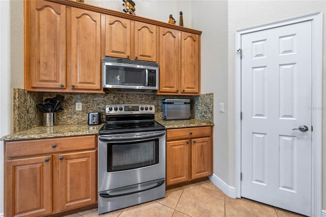 859 Leather Fern Ln, Mims, FL 32754 - kitchen featuring stainless steel appliances, tasteful backsplash, stone countertops, and light tile patterned floors