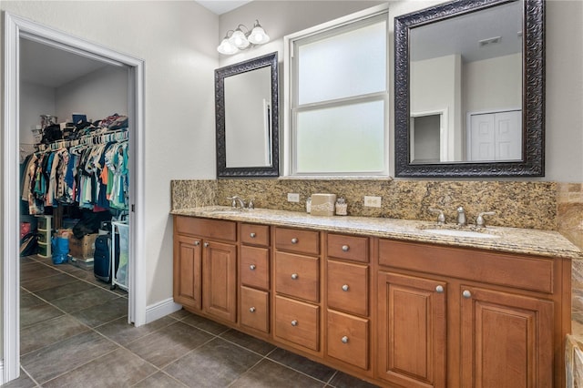 859 Leather Fern Ln, Mims, FL 32754 - bathroom featuring double vanity, tile patterned floors, decorative backsplash, and a spacious closet