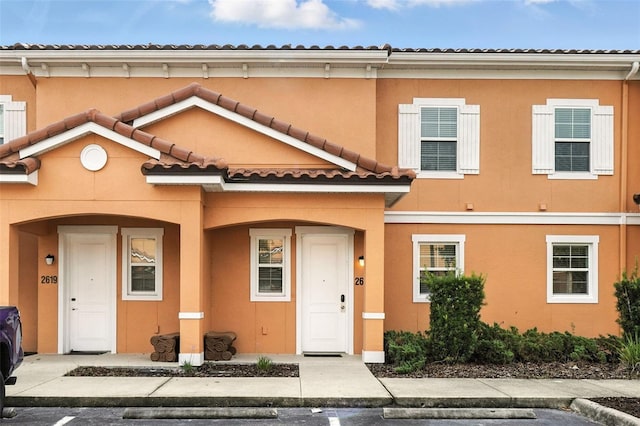 2617 Bugatti Ct, Kissimmee, FL 34746 - view of property featuring a tile roof, a porch, and stucco siding