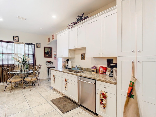 2218 W Gore St, Orlando, FL 32805 - kitchen with stainless steel dishwasher, white cabinetry, and light tile patterned floors