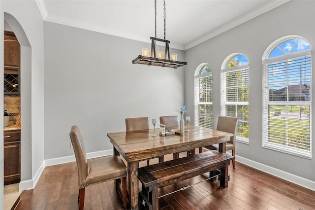 4323 Kezar Ct, Belle Isle, FL 32812 - dining room with crown molding, hardwood / wood-style floors, arched walkways, and a chandelier