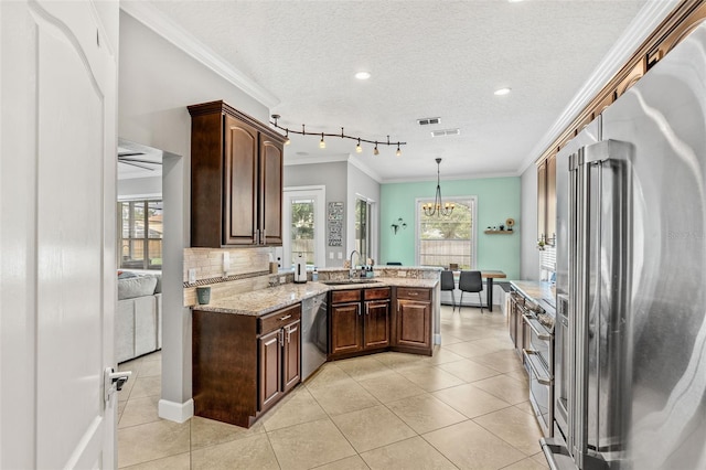 4323 Kezar Ct, Belle Isle, FL 32812 - kitchen featuring appliances with stainless steel finishes, ornamental molding, a textured ceiling, dark brown cabinets, and light stone countertops