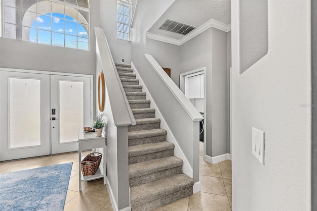 4323 Kezar Ct, Belle Isle, FL 32812 - foyer featuring light tile patterned floors, ornamental molding, stairway, and french doors