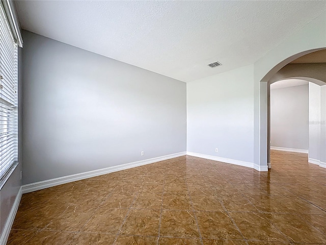 229 Largovista Dr, Oakland, FL 34787 - unfurnished room featuring arched walkways and a textured ceiling