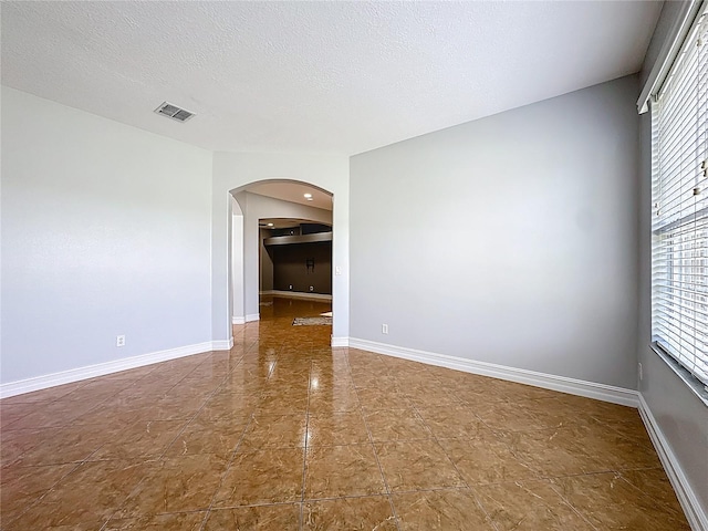 229 Largovista Dr, Oakland, FL 34787 - spare room with arched walkways and a textured ceiling