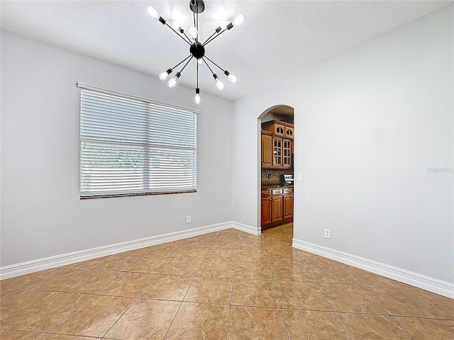 229 Largovista Dr, Oakland, FL 34787 - unfurnished room featuring arched walkways, a chandelier, light tile patterned floors, and a textured ceiling