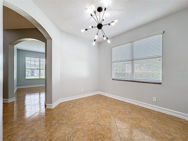 229 Largovista Dr, Oakland, FL 34787 - spare room featuring a chandelier, tile patterned floors, a textured ceiling, and arched walkways