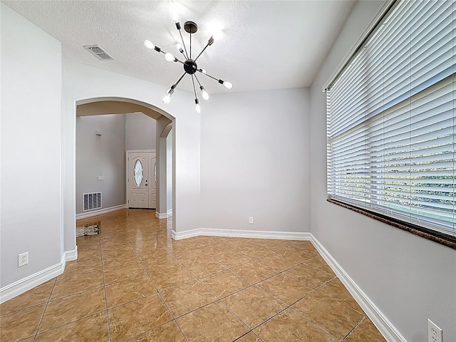 229 Largovista Dr, Oakland, FL 34787 - empty room with arched walkways, a chandelier, a textured ceiling, and light tile patterned floors