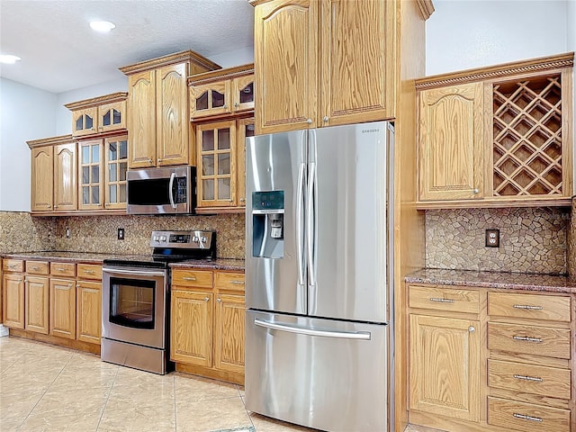 229 Largovista Dr, Oakland, FL 34787 - kitchen featuring stainless steel appliances, dark stone countertops, tasteful backsplash, glass insert cabinets, and recessed lighting