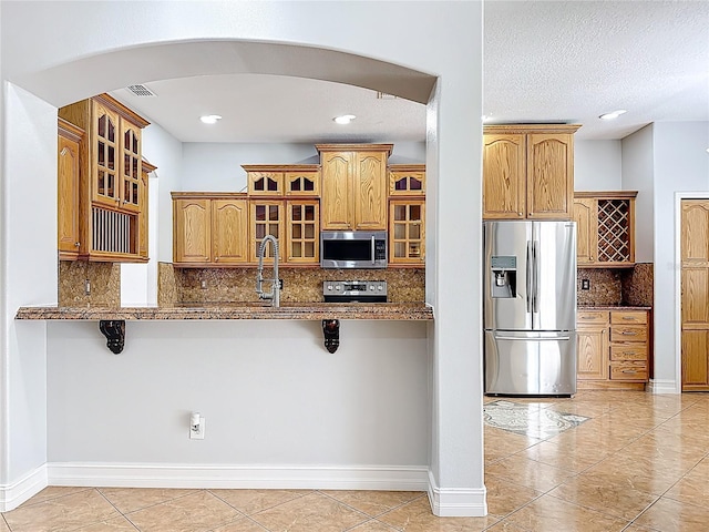 229 Largovista Dr, Oakland, FL 34787 - kitchen featuring appliances with stainless steel finishes, a kitchen bar, tasteful backsplash, light tile patterned floors, and recessed lighting