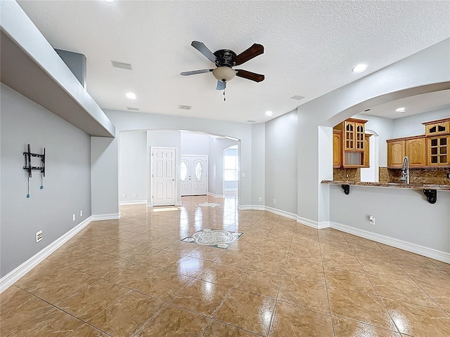 229 Largovista Dr, Oakland, FL 34787 - unfurnished living room with arched walkways, ceiling fan, a textured ceiling, recessed lighting, and light tile patterned floors