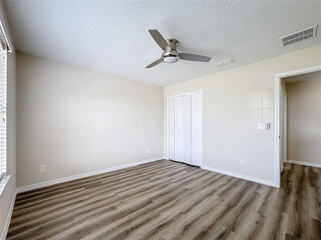 229 Largovista Dr, Oakland, FL 34787 - unfurnished bedroom featuring wood finished floors, a closet, a textured ceiling, and ceiling fan