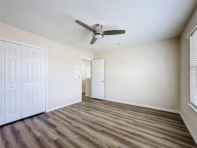 229 Largovista Dr, Oakland, FL 34787 - unfurnished bedroom featuring wood finished floors, a textured ceiling, a closet, and ceiling fan