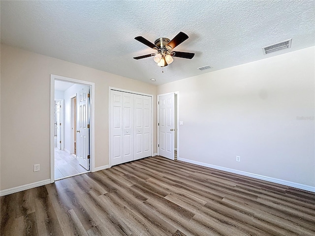 229 Largovista Dr, Oakland, FL 34787 - unfurnished bedroom featuring wood finished floors, a textured ceiling, ensuite bath, a closet, and ceiling fan