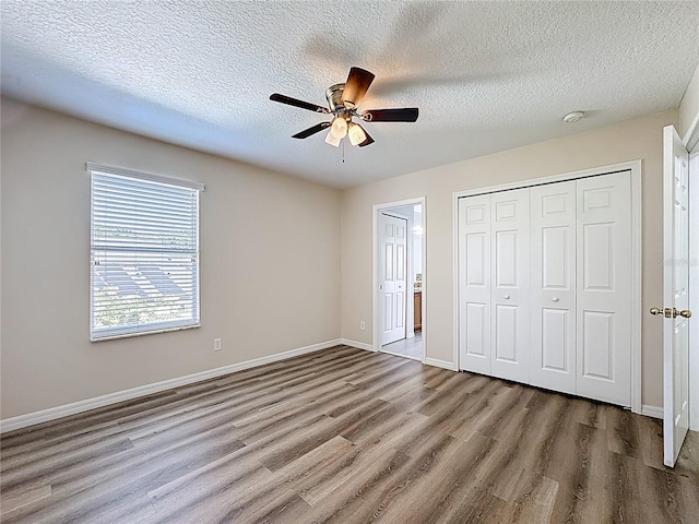 229 Largovista Dr, Oakland, FL 34787 - unfurnished bedroom featuring wood finished floors, a textured ceiling, a closet, and ceiling fan
