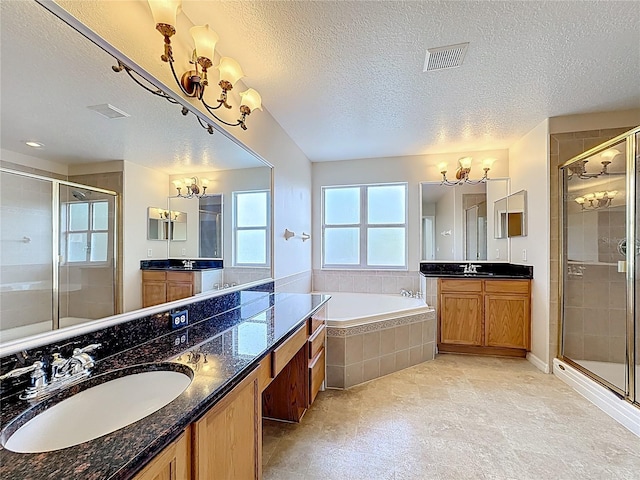 229 Largovista Dr, Oakland, FL 34787 - bathroom with a chandelier, a shower stall, a textured ceiling, two vanities, and a bath