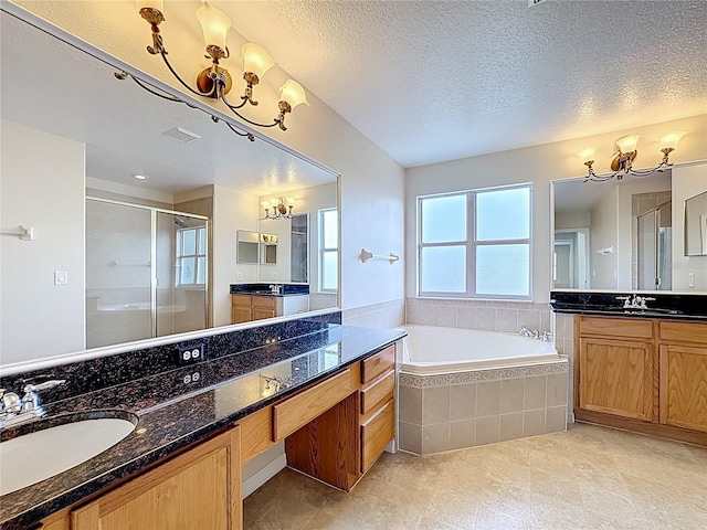 229 Largovista Dr, Oakland, FL 34787 - bathroom featuring a chandelier, a shower stall, two vanities, a textured ceiling, and a garden tub