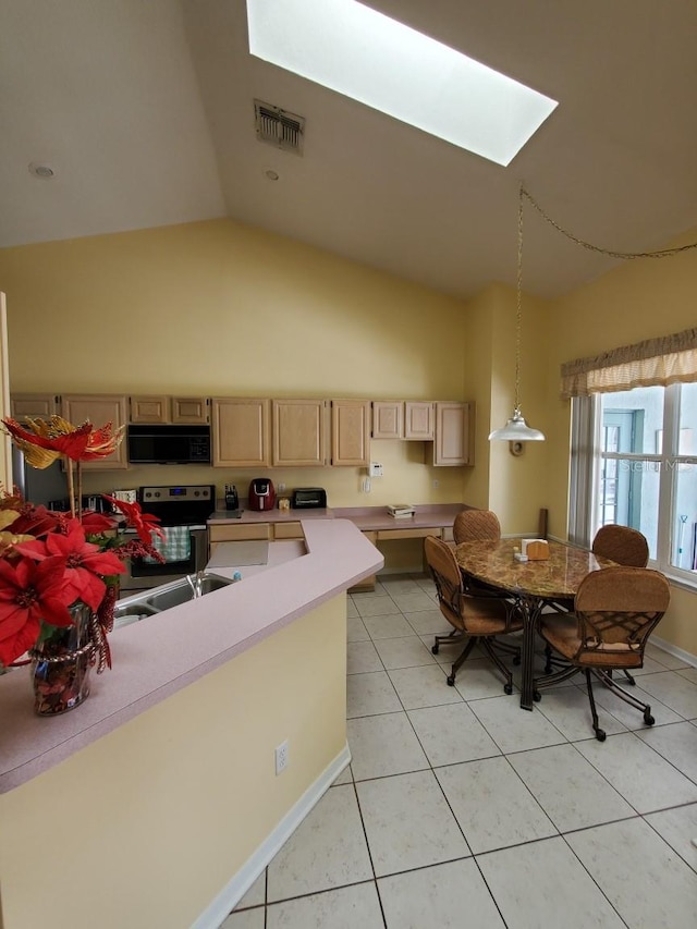 8630 Knottingham Dr, Kissimmee, FL 34747 - kitchen featuring black microwave, light brown cabinets, a skylight, lofted ceiling, and light tile patterned floors