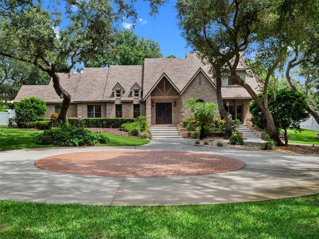 9045 Mossy Oak Ln, Clermont, FL 34711 - tudor home with curved driveway and brick siding