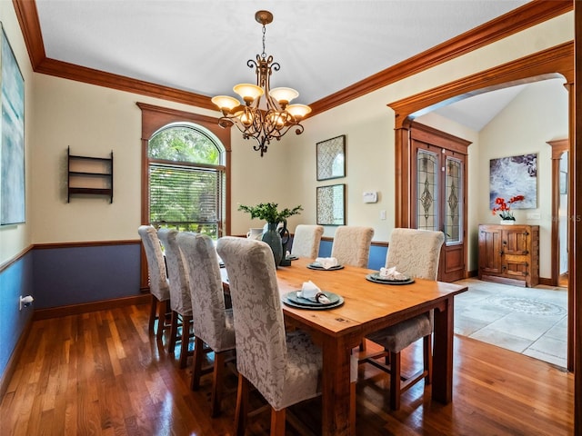 9045 Mossy Oak Ln, Clermont, FL 34711 - dining area with a chandelier, wood finished floors, crown molding, and arched walkways