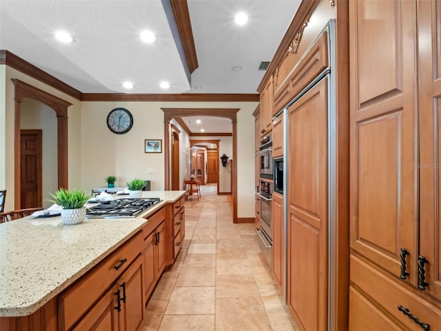 9045 Mossy Oak Ln, Clermont, FL 34711 - kitchen with a kitchen island, ornamental molding, light stone countertops, recessed lighting, and brown cabinetry