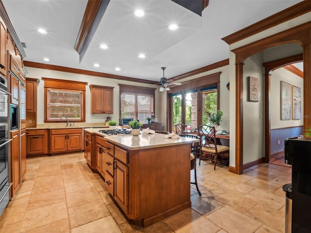 9045 Mossy Oak Ln, Clermont, FL 34711 - kitchen with crown molding, a center island, stone tile floors, recessed lighting, and a kitchen breakfast bar