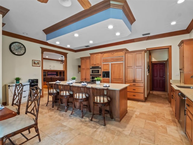 9045 Mossy Oak Ln, Clermont, FL 34711 - kitchen featuring paneled built in fridge, ornamental molding, double oven, a center island, and a kitchen bar