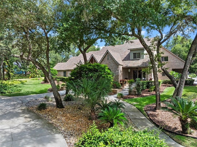 9045 Mossy Oak Ln, Clermont, FL 34711 - view of front facade with stone siding, a front yard, and stairs