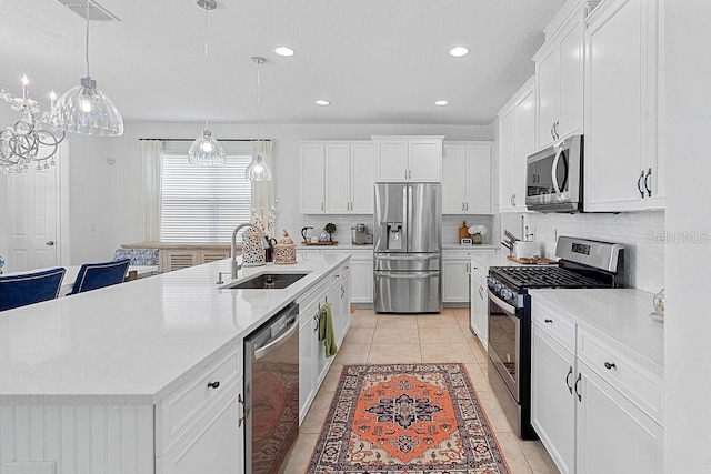 14897 Ellingsworth Ln, Winter Garden, FL 34787 - kitchen featuring appliances with stainless steel finishes, tasteful backsplash, a large island, white cabinets, and recessed lighting