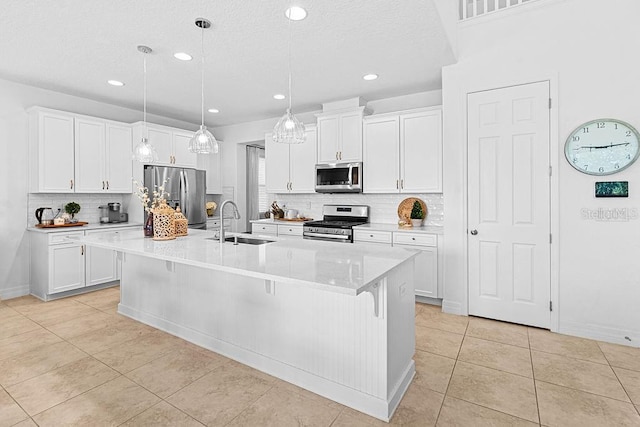 14897 Ellingsworth Ln, Winter Garden, FL 34787 - kitchen featuring appliances with stainless steel finishes, light tile patterned flooring, decorative backsplash, white cabinets, and recessed lighting
