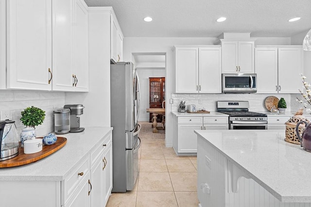 14897 Ellingsworth Ln, Winter Garden, FL 34787 - kitchen with appliances with stainless steel finishes, white cabinets, tasteful backsplash, and recessed lighting