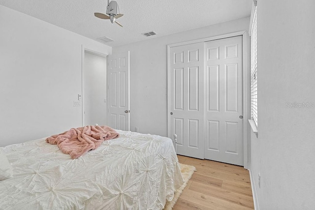 14897 Ellingsworth Ln, Winter Garden, FL 34787 - bedroom with light wood-style floors, a closet, a textured ceiling, and ceiling fan